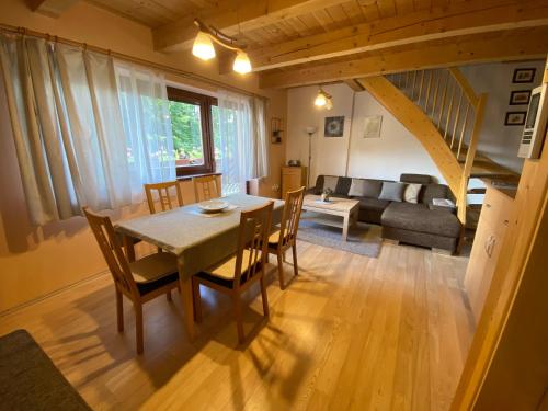 a dining room and living room with a table and chairs at Apartmán Donovaly Mišuty 586 in Donovaly