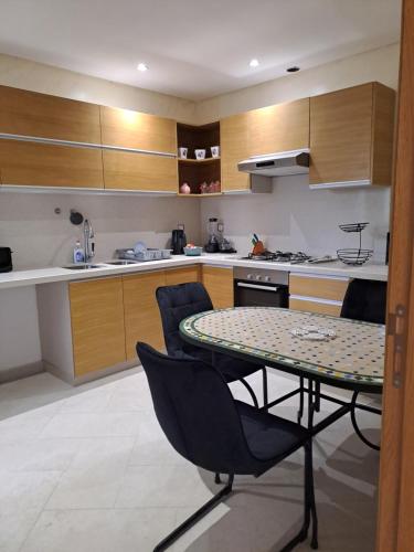 a kitchen with a table and chairs in a room at Couzi Haus Marina in Agadir
