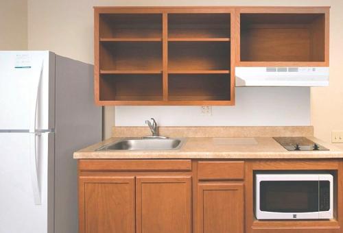 a kitchen with a sink and a microwave at WoodSpring Suites Macon West I-475 in Macon