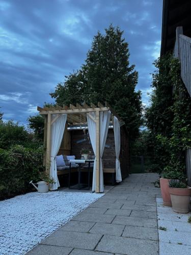 a pergola with a table and chairs under it at Apartment Wohlfühlplatzl - urgemütlich & ruhig in Vogtareuth