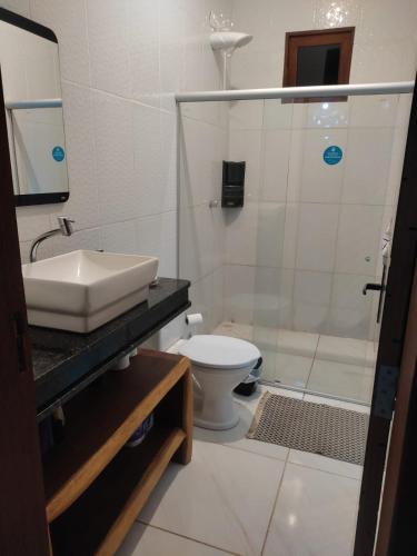 a bathroom with a shower and a sink and a toilet at Maison de plage à Santo Antonio in Santa Cruz Cabrália