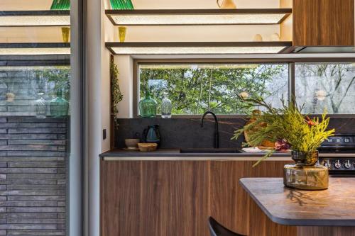 a kitchen with a sink and a window at Stylish lakehouse in idyllic, private green scenery in Stekene