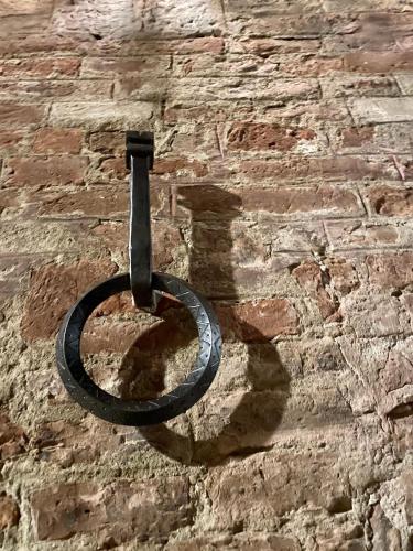 a black ring on the side of a brick wall at Torre del Fuggisole in Siena