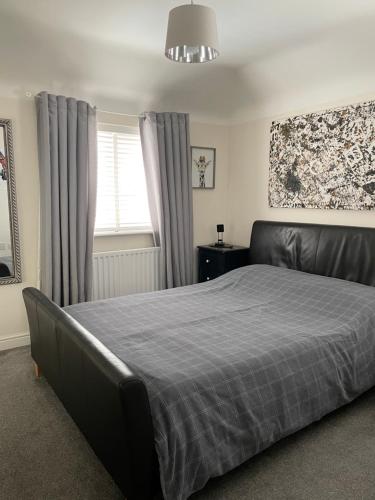 a bedroom with a large bed and a window at Home from home midlands in Glascote