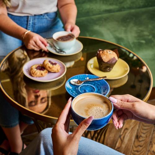 a group of people sitting around a table with cups of coffee at Genting Hotel & Spa at Resorts World Birmingham in Bickenhill