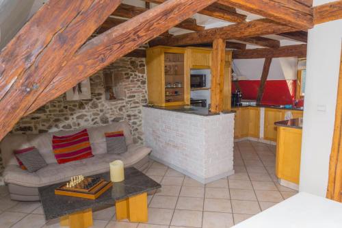 un salon avec un canapé et une cuisine dans l'établissement charmant appartement alsacien, à Ribeauvillé