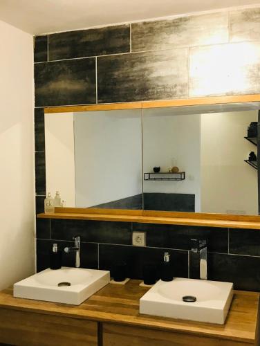 a bathroom with two white sinks and a mirror at L'Aparenthese - Aux portes de Fontainebleau in Voulx