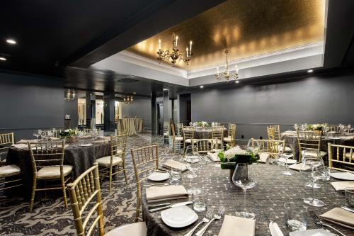 a dining room with tables and chairs and a chandelier at Fairmount Hotel, in the Unbound Collection by Hyatt in San Antonio