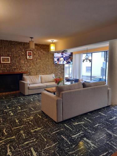 a living room with two couches and a fireplace at Hosteria Bello Horizonte in San Carlos de Bariloche