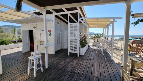 a wooden deck with a bar and chairs on it at LA VILLA fronte SPIAGGIA BANDIERA BLU in Sperlonga