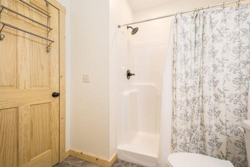 a bathroom with a shower curtain and a toilet at Johns Place in McHenry