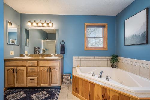 niebieska łazienka z wanną, umywalką i wanną w obiekcie Finns Four Seasons w mieście Swanton
