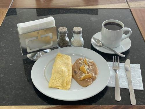 a plate of breakfast food with a donut and a cup of coffee at Hotel ANB Aeropuerto Guadalajara in Guadalajara