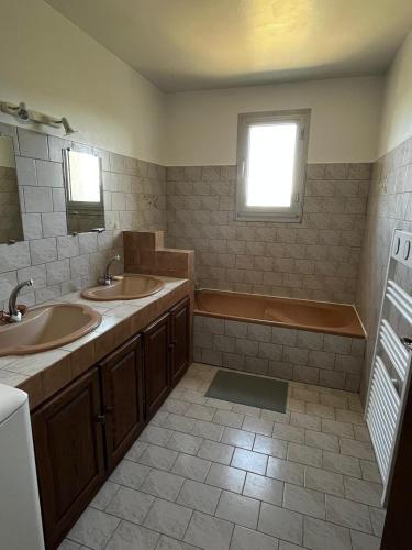 une salle de bain avec deux lavabos et une baignoire dans l'établissement Villa la Montée, à Mirabel-aux-Baronnies
