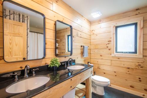 łazienka z 2 umywalkami i toaletą w obiekcie Camp Wondermore w mieście Swanton