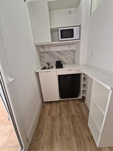 a small kitchen with white cabinets and a microwave at ESTACIÓN JOAQUÍN SOROLLA MyHomeStay in Valencia