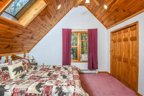 1 dormitorio con cama y techo de madera en Black Bear Retreat, en Swanton