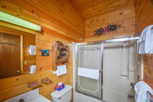 ein Bad mit einer Dusche an einer Holzwand in der Unterkunft Sunset Ridge in McHenry