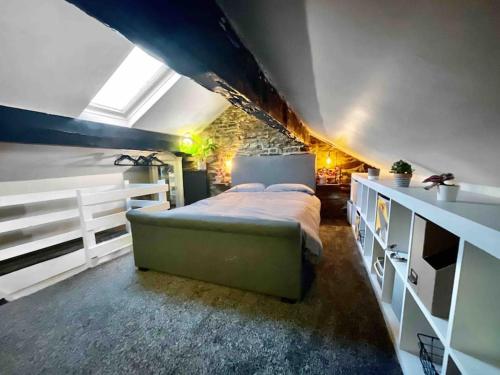 a bedroom with a large bed in a attic at Peak District Self Catering Holiday Home in Glossop