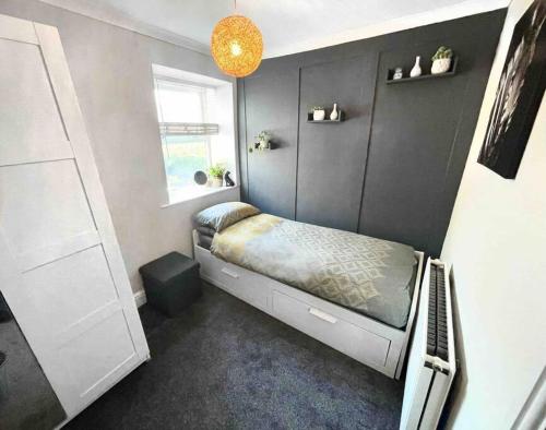 a small bedroom with a bed and a window at Peak District Self Catering Holiday Home in Glossop