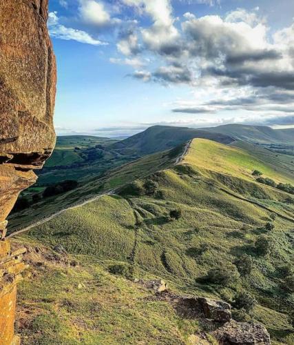 a view of a grassy hillside with a cliff at Peak District Self Catering Holiday Home in Glossop