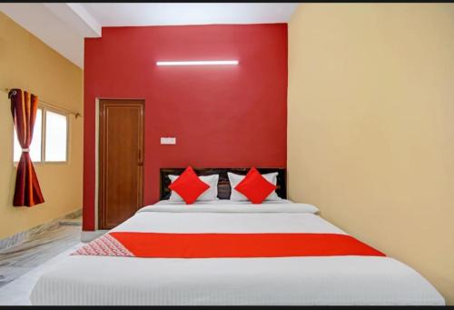 ein Schlafzimmer mit einem großen Bett mit einer roten Wand in der Unterkunft Fantasy Stay Fusion in Kalkutta