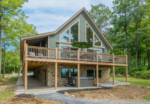a house with a wrap around porch with a deck at Woods-Stock in McHenry