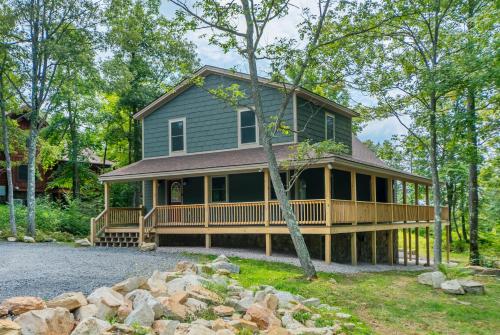 a green house with a large deck in the woods at Woods-Stock in McHenry
