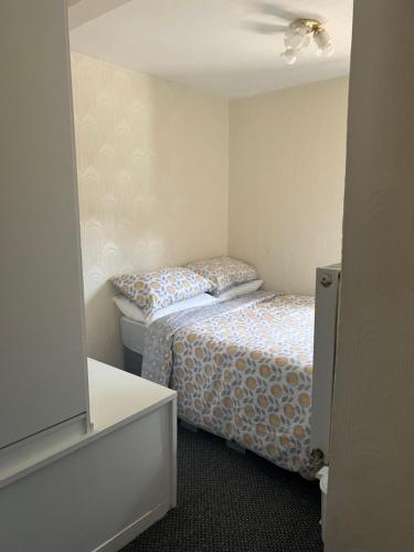 a small bedroom with a bed and a television at Cosy 2 bedroom flat in London