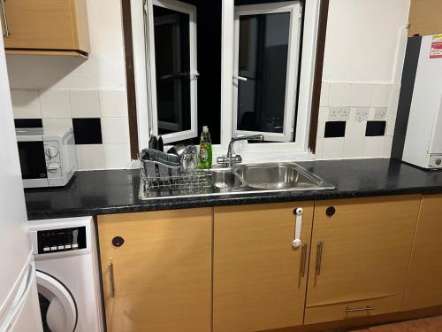 a kitchen with a sink and a microwave at Cosy 2 bedroom flat in London