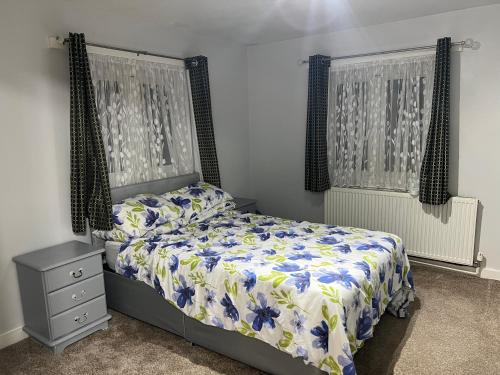 a bedroom with a bed with a blue and white comforter at Cosy 2 bedroom flat in London