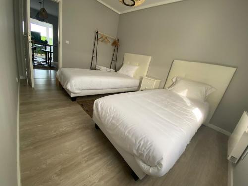 duas camas num quarto com lençóis brancos em Casa da Capela em Aveiro