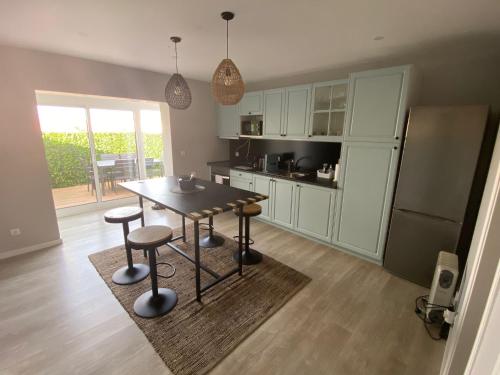 uma cozinha com uma mesa, bancos e um frigorífico em Casa da Capela em Aveiro