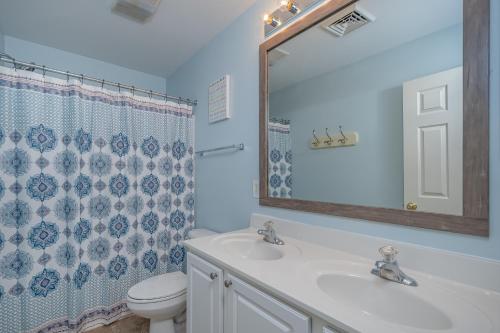 a bathroom with a sink and a toilet and a mirror at Carmel Sunday in Swanton