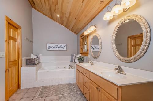 La salle de bains est pourvue d'une baignoire, d'un lavabo et d'un miroir. dans l'établissement Bear Hollow Lodge, à Oakland