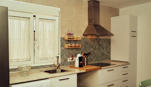 a kitchen with a sink and a stove at Casas Rurales El Tajo in Setenil