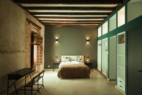 a bedroom with a bed and a table in a room at Casa de los Mendoza - Casa Solariega en el casco histórico in Alcalá de Henares