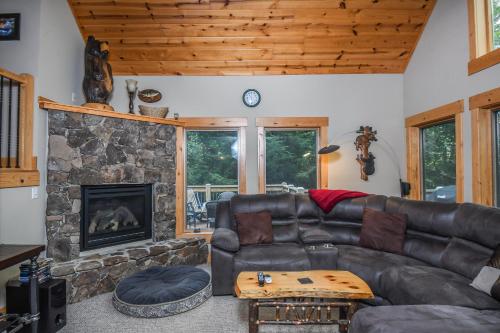 a living room with a leather couch and a stone fireplace at Canopy Escape in McHenry