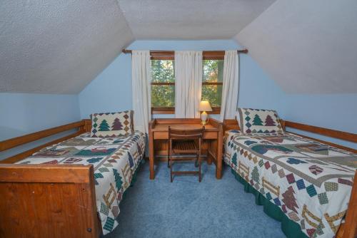 um quarto com 2 camas, uma secretária e uma mesa em The Pines em Swanton