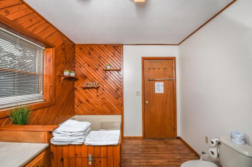 een badkamer met een toilet en een houten muur bij Camp - Deep - Creek in Accident
