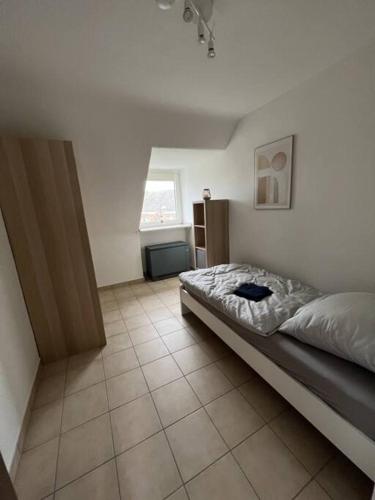 1 dormitorio con 1 cama y suelo de baldosa en MG 32 59m² große Unterkunft für bis zu 5 Personen, en Mönchengladbach