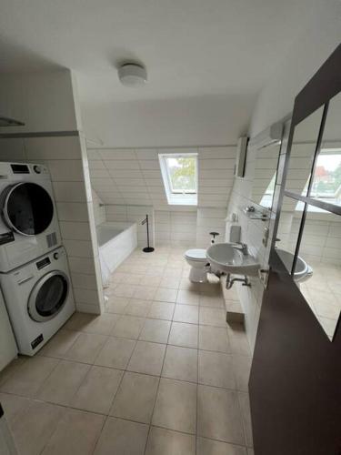 a bathroom with a toilet sink and a washing machine at Große Unterkunft für bis zu 5 Personen MG32 in Mönchengladbach