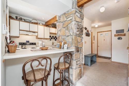 a kitchen with two chairs and a stone wall at Ski Harbor 14 in McHenry
