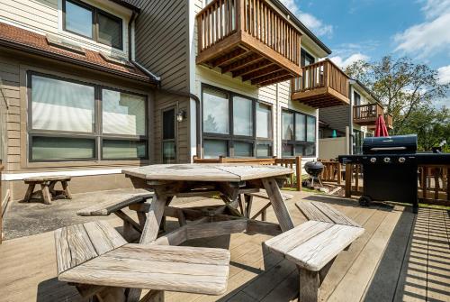 a picnic table and benches on a patio with a grill at Ski Harbor 14 in McHenry