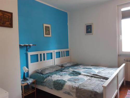 1 dormitorio con 1 cama con pared azul en Casa Ananda en Sorso