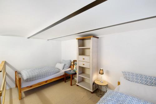 クサンテンにあるTiny Appartment Xanten am Seeのベッドルーム(ベッド2台、本棚付)