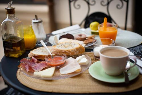 a table with a plate of food and a cup of coffee at El Patio de los Jazmines Boutique-House in Consuegra
