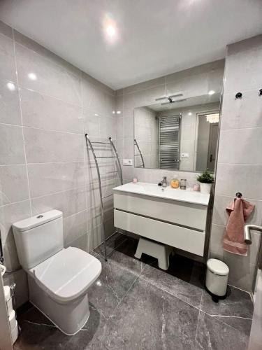 a bathroom with a white toilet and a sink at Amplio apartamento tranquilo cerca de la playa in Roses
