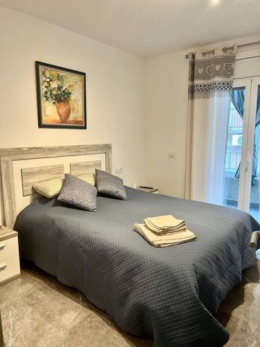 una camera da letto con un letto e asciugamani di Amplio apartamento tranquilo cerca de la playa a Roses