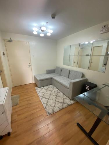 een woonkamer met een bank en een tapijt bij Seawind 2 bedroom comfort in Davao City